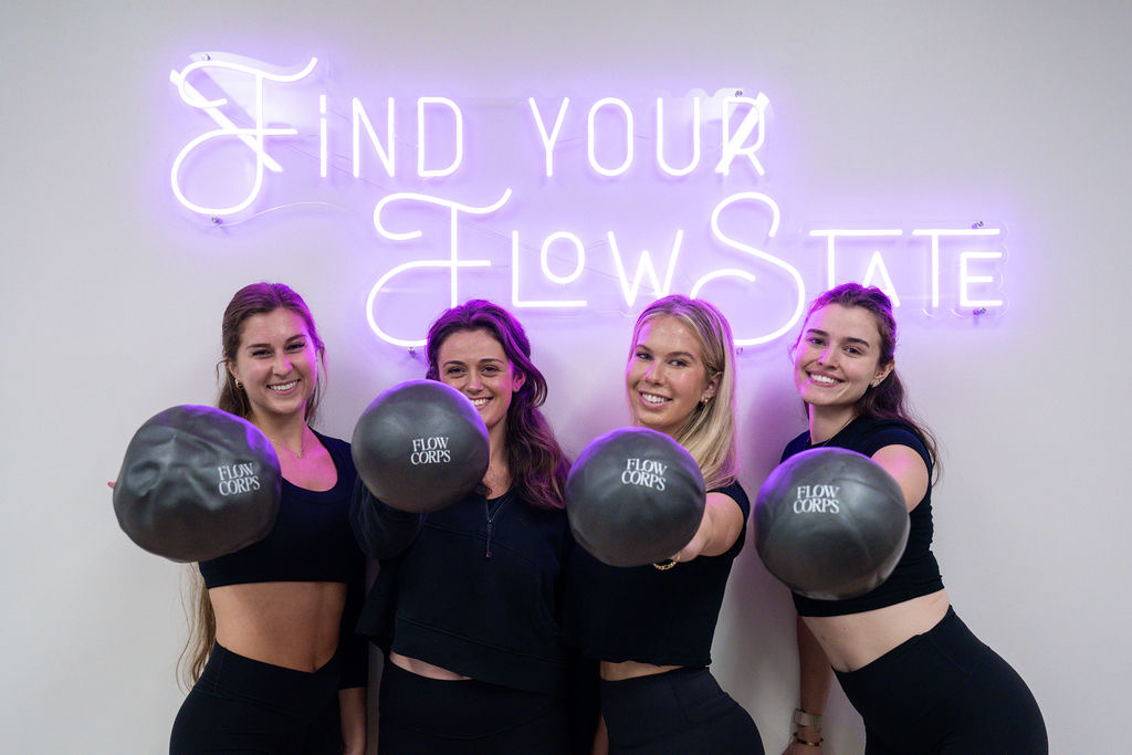 FlowCorps team with Find Your FlowState neon sign
